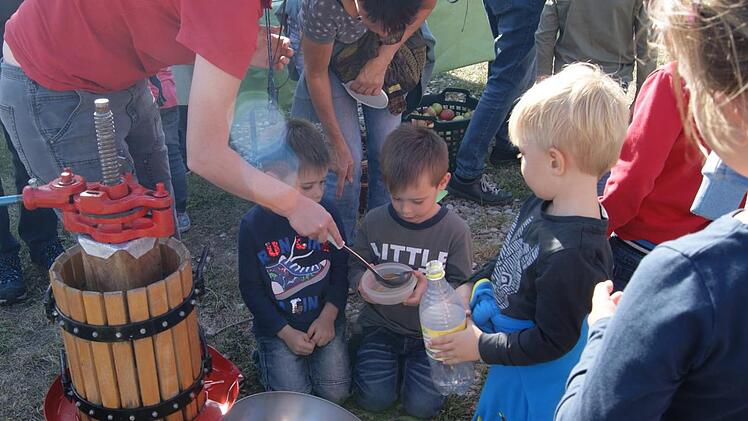 Ceara Elhardt verteilt frischen Apfelsaft aus der Handpresse. Foto: Ulrike Schaefer