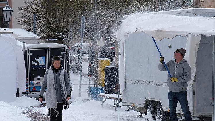 In der Nacht vor dem Frühjahrsmarkt hat es geschneit, und der Schnee musste von der Straße und von den Stoffdächern geräumt werden. Foto: Gerd Schaar