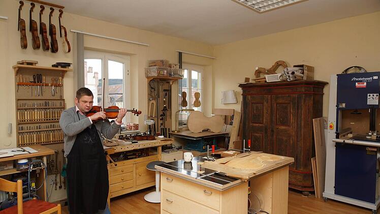 Jascha Hellberg spielt in der Werkstatt auf einer selbst gebauten Geige. Foto: Arkadius Guzy
