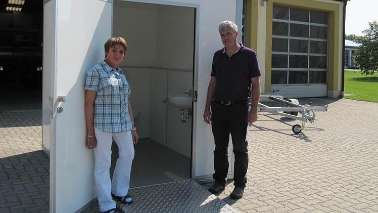 Lydia Trütschel, Behindertenbeauftragte der Gemeinde, inspiziert mit Bürgermeister Bernhard Storath das neue mobile behindertengerechte Toilettenhäuschen. Rechts im Hintergrund steht der zum Transport benötigte Anhänger.  Fotos: Monika Schütz