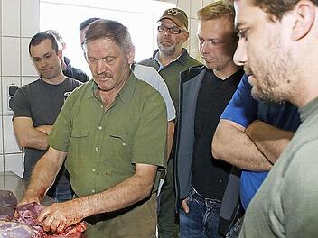 Angehende Waidmänner aus ganz Unterfranken lernen von Karl Jäger (vorne am Tisch) das Schlachten und Zerlegen von Wild. Mittlerweile kam der 25. Kurs im Rahmen der Vorbereitung auf die Jägerprüfung auf den Hof in Tretzendorf.  Foto: Sabine Weinbeer