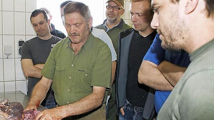 Angehende Waidmänner aus ganz Unterfranken lernen von Karl Jäger (vorne am Tisch) das Schlachten und Zerlegen von Wild. Mittlerweile kam der 25. Kurs im Rahmen der Vorbereitung auf die Jägerprüfung auf den Hof in Tretzendorf.  Foto: Sabine Weinbeer