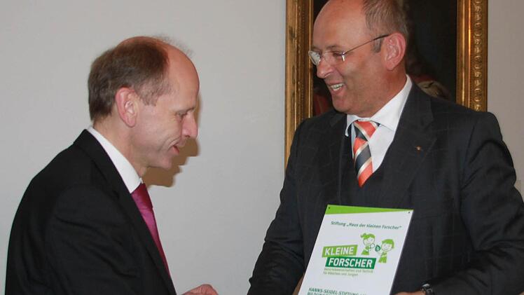 IHK-Präsident Heribert Trunk zeichnet den Verwaltungsleiter der Hanns-Seidel-Stiftung, Michael Möslein, mit der Partnerplakette aus, weil er das Bildungshaus in Kloster Banz von Beginn an für Workshops zur Verfügung gestellt hat. Fotos: Matthias Einwag