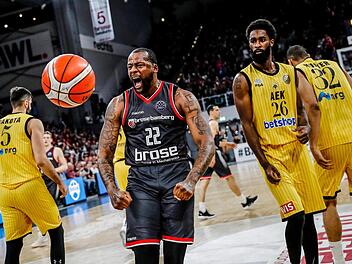 Cliff Alexander nach einem Dunking in Jubelpose. Das Bamberger Kraftpaket war unter den Körben nicht zu stoppen; rechts AEK-Spieler Howard Sant-Roos, der den Bamberger Aufbauspieler Tyrese Rice an die Kette legte. Foto: Daniel Löb