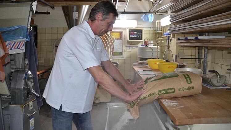 Matthias Fischer in seiner Backstube. Hier füllt er frisches Mehl auf. Foto: Kathrin Kupka-Hahn