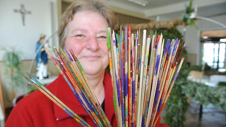 Nein, das ist kein Mikado-Spiel. Auf die Stäbchen, zeigt Lisa Moser, werden die Eier gespießt, wenn sie angemalt werden sollen. So können sie gut trocknen.