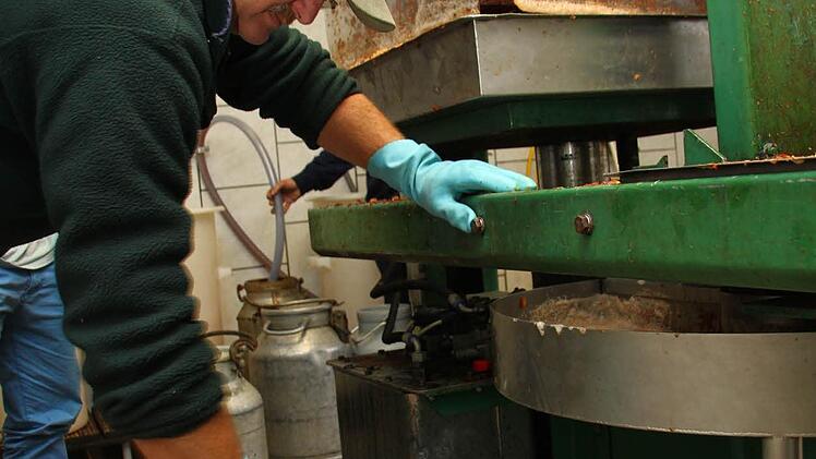 Die Trübstoffe, die mit einem Sieb aus dem Saft gefiltert werden, zieht Wilfried Högen ab.