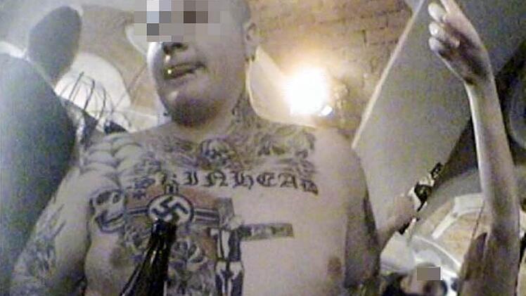 Ein Skinhead stellt bei einem Neonazi-Konzert am 9. Dezember 2006 in Mitterding (Österreich) sein Hakenkreuz-Tattoo zur Schau. Organisiert war das Konzert von Deutschen, die es kurzfristig über die Grenze verlegt hatten.