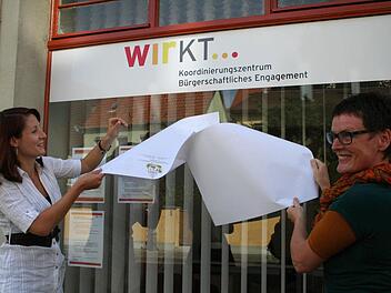 Sandra Thren und die Wettbewerbsgewinnerin Gabi Bergauer aus Astheim enthüllen das neue Logo der Ehrenamtsstelle.  Foto: Paulus