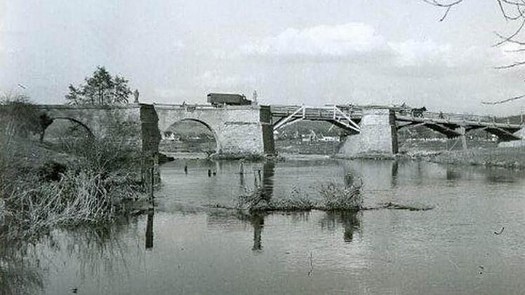 Eine Ansicht der Regnitzbrücke aus der Nachkriegszeit (1952). Der heute nicht mehr vorhandene rechte Abschnitt wird von einer Holzkonstruktion überspannt. Dort wurde mit Erdreich aufgefüllt, weiter rechts verläuft der Main-Donau-Kanal. Fotos: Stadtarchiv Forchheim/Repro: Rainer Kestler (2)/Martin Rehm (2)
