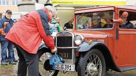 Johannes Deinlein gibt einer BMW Dixi, Baujahr 1930, bei der Bocksbeutelrallye 2013 Starthilfe. Foto: Archiv/ Arkadius Guzy