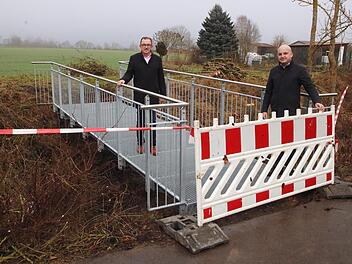 Die neue Stahlbrücke, die in der Verlängerung der Pfarrer-Kunzmann-Straße  über die Wannig in Großwenkheim führt, besichtigten Stadtrat Arno  Schlembach (links) und Bürgermeister Michael Kastl (rechts). Foto: Dieter  Britz