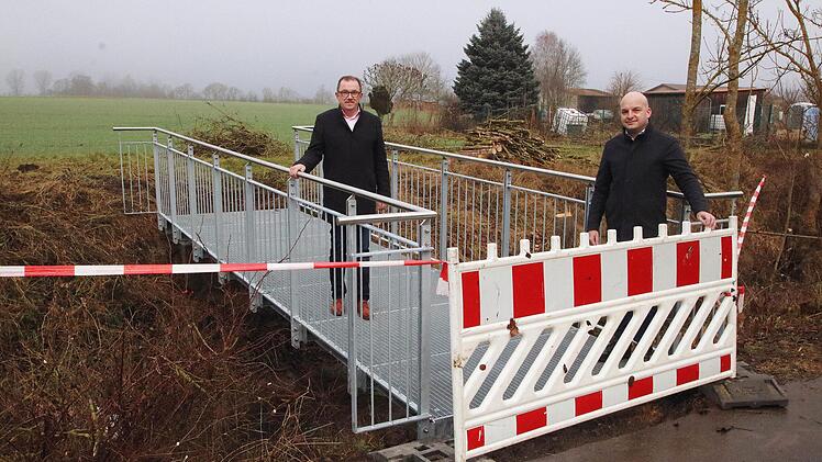 Die neue Stahlbrücke, die in der Verlängerung der Pfarrer-Kunzmann-Straße  über die Wannig in Großwenkheim führt, besichtigten Stadtrat Arno  Schlembach (links) und Bürgermeister Michael Kastl (rechts). Foto: Dieter  Britz