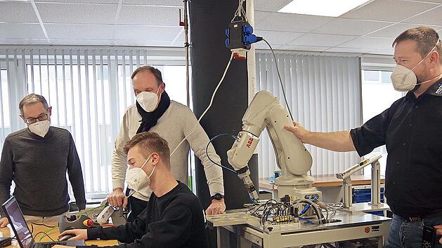 Im Auszubildenden-Zentrum der Firma M.A.i. in Neuses schauen (von links) David M&aacute;rquez, Werner Zahner und Tobias Geiger dem Azubi Marius (vorne) &uuml;ber die Schulter.