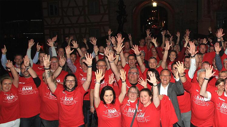 Brose Bamberg auf der Oberen Brücke: Kick-Off-Gruppenfoto mit den neuen "Bambeat"-Play-Off-Shirts vor dem Rathaus. Die Vorfreude mit dem "roten Herzschlag" war am Donnerstagabend deutlich zu spüren. Foto: Bertram Wagner
