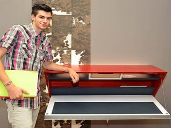 "Red Keily" nennt Patrick Heisler sein Gesellenstück, eine witzige Komposition eines keilartigen Möbels das zwei Nutzungsvarianten vereint. So kann der Benutzer es sowohl stehend, wie auch davor sitzend mit geöffneter Türklappe nutzen. "Rattenscharf kommt die Buche, in witziger Verleimung 'rot getaucht mit weißer Klappe' daher", so Patrick Heisler in der Beschreibung seines Gesellenstückes.  Foto: Peter Rauch