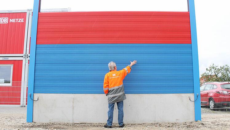 Ein Bahn Mitarbeiter demonstriert das Größenverhältnis Lärmschutzwände. Diese Beispielwand ist in den Farben der Marktgemeinde Ebensfeld gestaltet. Über die tatsächliche Farbgebung entscheidet die Gemeinde.  Fotos: Thomas Heuchling