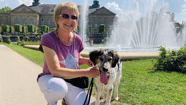 Birgit Bollwein mit ihrem Hund Clooney im Rosengarten.