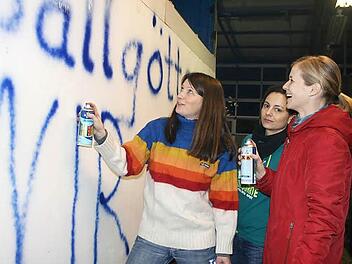 Katrin Schwalb, Antje Düthorn und Kathrin Weißerth (von links) sprühen das Motto auf ihren Faschingswagen.Foto: Veronika Schadeck