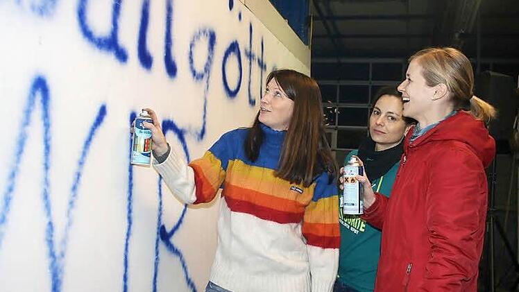 Katrin Schwalb, Antje Düthorn und Kathrin Weißerth (von links) sprühen das Motto auf ihren Faschingswagen.Foto: Veronika Schadeck