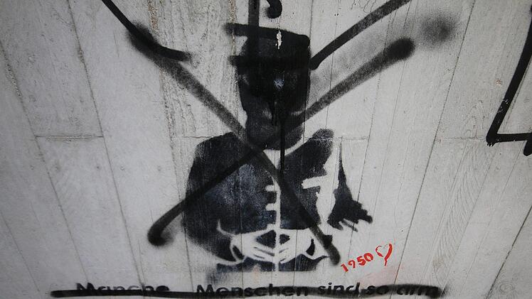 Dieses Graffito an der Südbrücke "geht schon in Richtung Street-Art. Allerdings fehlt es auch hier an  Qualität, und es wirkt ebenfalls unfertig", sagt der Bad Kissinger Maler. Zu dem Bild gehören die Worte: "Manche Menschen sind so arm, alles was sie haben ist Geld." Im Nachhinein hat jemand Bild und Text durchgestrichen. "Das ist ein bildlicher Meinungsaustausch." Jemand tut seine Meinung kund, jemand mit einer anderen Meinung übermalt das Ganze. "Ein Bild im öffentlichen Raum ist Kritik au...