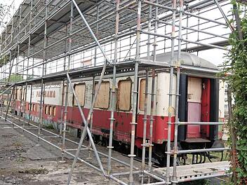 Der Waggon wird komplett eingehaust, damit er sandgestrahlt werden kann. Die Fenster wurden von der Glaserei Späth ausgebaut und gesichert. Fotos: Simone Bastian (2), Stadt Coburg (1)