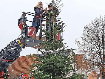 Die Initiatoren vom Team "Pro Spaß" haben nur die Spitze des Weihnachtsbaumes am Adelsdorfer Marktplatz geschmückt. Jetzt dürfen die Bürger weitermachen.  Foto: Johanna Blum