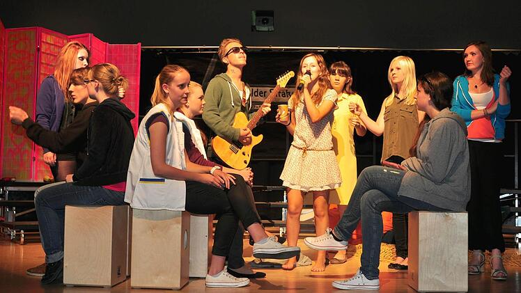 Szenen einer Großstadt: das Theaterstück "Auf der Greifswalder Straße" von Roland Schimmelpfennig wurde von der Theatergruppe der Mittel- und Oberstufe des Regiomontanus-Gymnasiums Haßfurt unter der Regie von Katrin Hiernickel mit der Projektband unter der Leitung von Alexandra Weber ganz wunderbar zum Leben erweckt. Unser Bild zeigt (von links) Maxine Korn, Jakob Stuhlfelder, Elisabeth Melber, Lisa-Marie Behrendt, Jessica Schmidtke, Moritz Schuck, Sophia Rein, Lea Sidon, Paulina Heumann, Lau...