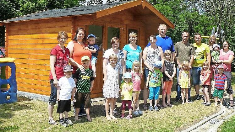 Bei der offiziellen Übergabe der neuen Spielhütte für die Rugendorfer Kindergartenkinder gab es nur zufriedene Gesichter. Das Gebäude, das die Mitglieder des Fördervereins in Eigenleistung erstellt haben, bietet viel Platz, um alle Spielsachen unterbringen zu können. Unser Bild zeigt Vorsitzende Sonja Witzgall (Bildmitte) im Kreis der fleißigen Eltern und Erzieherinnen des Kindergartens Regenbogen in Rugendorf. Foto: Klaus-Peter Wulf