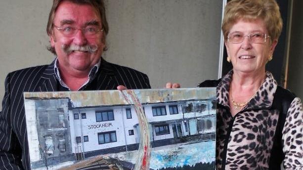 Rechtsanwalt Josef Geiger überraschte die Seniorchefin Johanna Blumenröther mit einem Gemälde, das die Fortentwicklung der Firma durch Edgar und Johanna Blumenröther seit 1961 zum Inhalt hat. Das Gemälde fertigte der Kronacher Künstler Martin Ludwig an.  Foto: Gerd Fleischmann