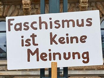Hamburg: Eine Transparent mit der Aufschrift ·Faschismus ist keine Meinung· hängt an einem Laternenmast auf dem Rathausmarkt. Im Hintergrund bilden die Teilnehmer der Demonstration der Organisation «Omas gegen Rechts» unter dem Motto «Keine Macht den Rechten! -Keine AfD in unser Rathaus!» eine Menschenkette am Rathaus. Foto: Georg Wendt/dpa