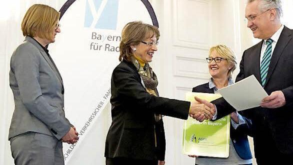 Herzogenaurachs Zweite Bürgermeisterin Renate Schroff erhält bei der zentralen Jahresabschlussveranstaltung aus den Händen von Verkehrsminister Joachim Herrmann die Auszeichnung "Fahrradfreundliche Kommune".  Foto: Tobias Hase/AGFK Bayern