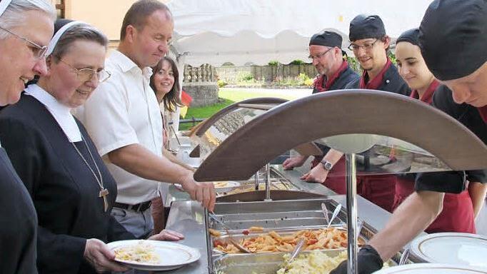 Die Generalökonomin Sr. Marianne Rauner und Generaloberin Sr. Edith Schlachter stehen zusammen mit Gesamtleiter Rainer Waldvogel und Anne Hilpert am Buffet, wo sie von den Mitarbeitern des Klostergasthofes bedient werden. Foto: Heike Beudert