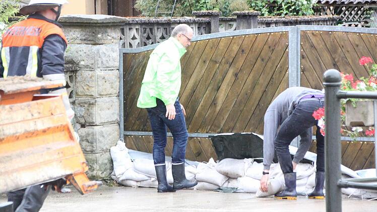 Vorsorglich werden am Freitagfrüh die Hofeinfahrten mit Sandsackbarrieren abgedichtet, falls der Pegel des Kelbachs noch steigen sollte. Foto: Matthias Einwag