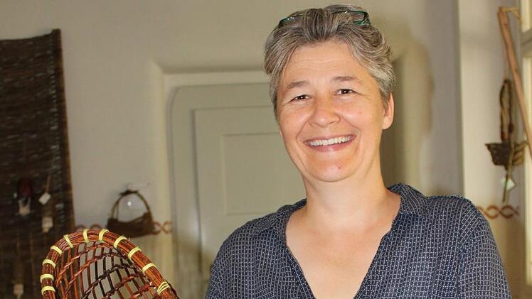 Henny Riedl, eine der beiden Leiterinnen der Sommerakademie Flechten, ist auch selbst als Dozentin tätig: Sie vermittelt das "Burkina-Geflecht", mit dem luftige Taschen oder Gefäße wie im Bild zu sehen hergestellt werden. Foto: Popp