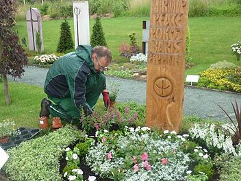 Mehrere Möglichkeiten einer pflegeleichten und dennoch attraktiven Grabbepflanzung zeigen Betriebe des Gärtnerrings Haßberge auf der Landesgartenschau in Bayreuth. Hier Obermeister Dietmar Hofmann bei der Anlage eines Mustergrabes.