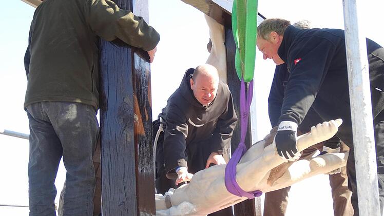 Einige Mühe und Kraftanstrengung war notwendig, bis die Christusfigur wieder am Kreuz angebracht war. Foto: Marion Eckert
