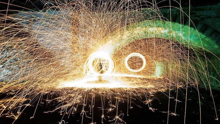 Da fliegen die Funken: Mit brennenden Metallspänen in einem Schneebesen lassen sich per Langzeitbelichtung und dem Zufallsprinzip wundervolle Aufnahmen kreieren - etwa diese, die an einer Eisenbahnüberführung in Lichtenfels entstanden ist. Fotos: Stefan Hemmerlein