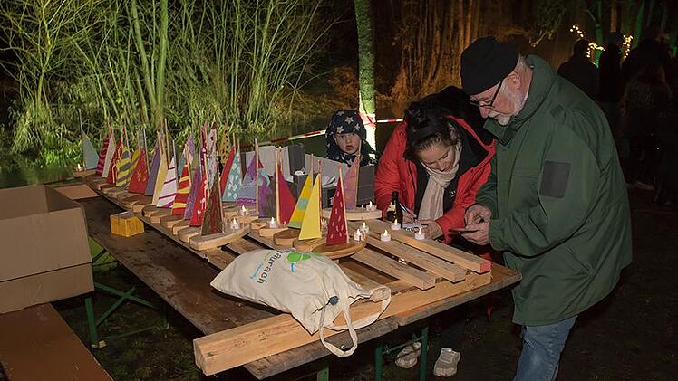 Die „Bootsverleiher“ Raphael, Andrea und Werner machen die beleuchteten Boote für die Fahrt auf der Aurach startklar.