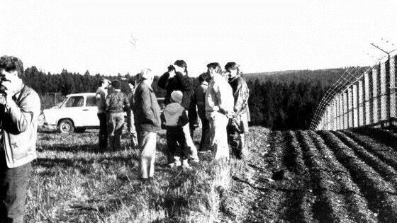 DDR-Bürger besichtigen den Todesstreifen und den Metallgitterzaun in der Nähe des Grenzübergangs. Der Streifen vor dem Zaun wurde immer frisch geeggt, damit man Spuren von Flüchtenden erkennen konnte. Foto: Archiv