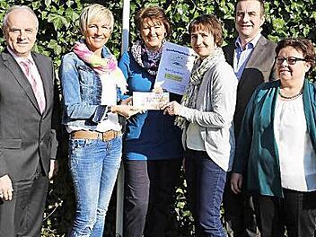 Bei der Preisverleihung übergeben Barbara Dümmler und Christine Trautner den Gewinn an Christine Bauer. Links stehen Bürgermeister Markus Grüner, rechts Bürgermeister Stefan Förtsch und Sylvia Müller.