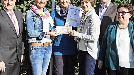 Bei der Preisverleihung übergeben Barbara Dümmler und Christine Trautner den Gewinn an Christine Bauer. Links stehen Bürgermeister Markus Grüner, rechts Bürgermeister Stefan Förtsch und Sylvia Müller.