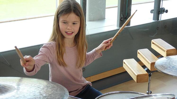 Besonders vom Schlagzeug fasziniert war bei einer Instrumenten-Rallye nach dem Kinderkonzert Lorena Diehm (7) aus Zeil. Foto: Christian Licha