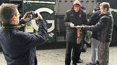 Die litauischen Basketball-Fans sichern sich vor dem Spiel in der Zalgirio Arena ein Autogramm des Bambergers Lucca Staiger. Foto: Brose Baskets
