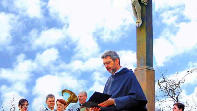 Pater Rudolf Götz OSA segnete das sanierte Feldkreuz am Wanderweg von Münnerstadt nach Fridritt; im Hintergrund Mitglieder der Musikkapelle Fridritt, die die Feier musikalisch gestalteten.  Foto: Dieter Britz