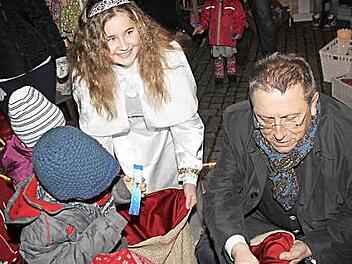 Begehrt waren die Süßigkeiten, die Christkind Hannah Sophie Sommer und Oberbürgermeister Henry Schramm verteilten. Fotos: Jochen Nützel