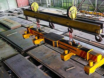 Betriebsunfall, Arbeitsunfall, Halle, Kran, Magnettraverse, Traverse, Br&uuml;ckenkran mit magnetischer Greifertraverse zum Heben von Stahlblechen. Industrieller Bereich in Innenr&auml;umen