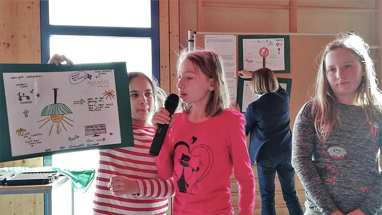 Schülerin Laura Friedel (Mitte) berichtet anhand von Postern über die Aktivitäten der kürzlich in der Grundschule Burkardroth gegründeten Umweltgruppe. Foto: Sigismund von Dobschütz