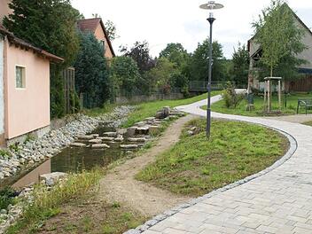 Mit mehreren kleineren Maßnahmen läuft derzeit die letzte Phase der Dorferneuerung im Ortskern von Kirchaich. Hier ein Blick auf den erneuerten Fußweg zwischen Kaulberg und Ballsieperstraße, wo jetzt auch der Schößbach als Wasserspielplatz zugänglich ist.  Sabine Weinbeer