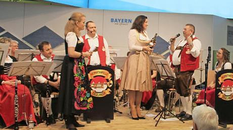 Nach dem Auftritt in der Bayernhalle der Grünen Woche gesellte sich Staatsministerin Dorothee Bär zu den Musikern aus Ziegelanger auf die Bühne und nahm dankend vom Orchestervorstand Günter Stößel ein Präsent der Heimatkapelle entgegen.  Foto: Heimatkapelle Ziegelanger